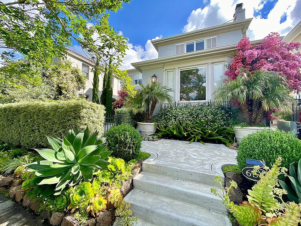 A garden walk-up to a traditional Crocker Highlands home with flowering shrubs framing a flagstone path to the front door